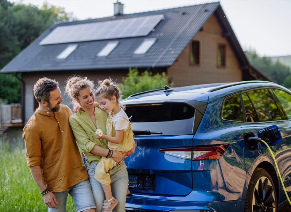 Insurance Solutions - Family With Little Girl Standing in Front of Their House With Solar Panels on the Roof